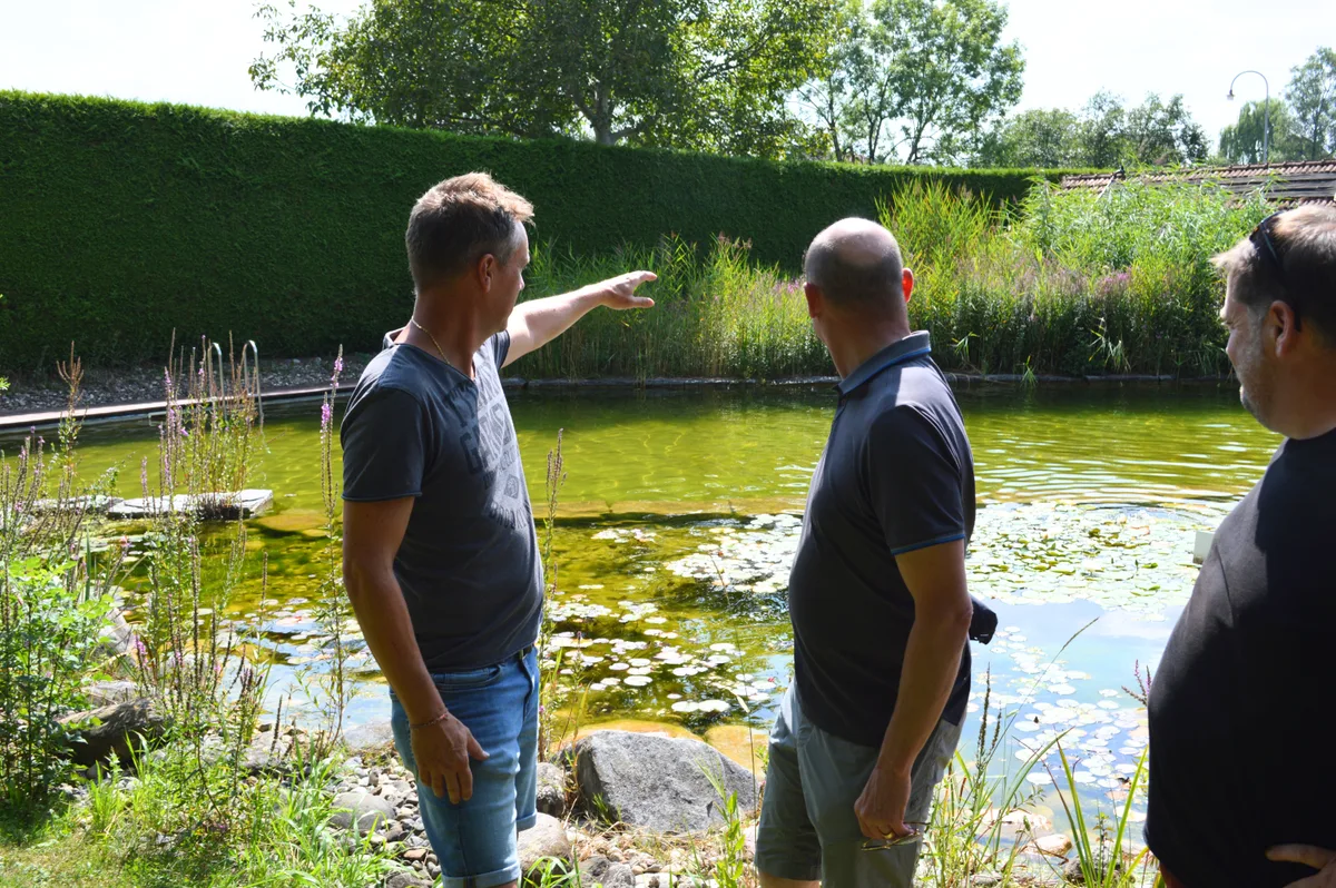 Ein Würfel auf dem Wasser soll zur Bühne werden. Ein Mann zeigt auf das Naturbad der Badi Bisikon.